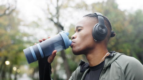 Hombre,-Auriculares-Y-Agua-Potable-En-El-Parque.