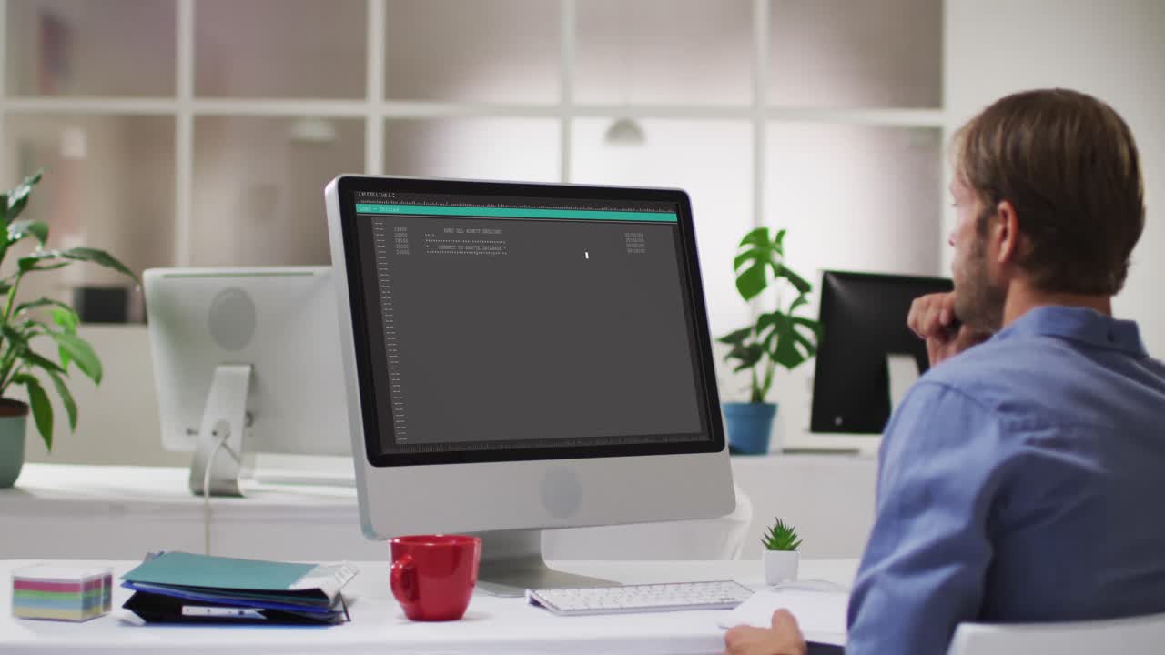 책상에 앉아서 노트북으로 데이터를 코딩하는 백인 남성