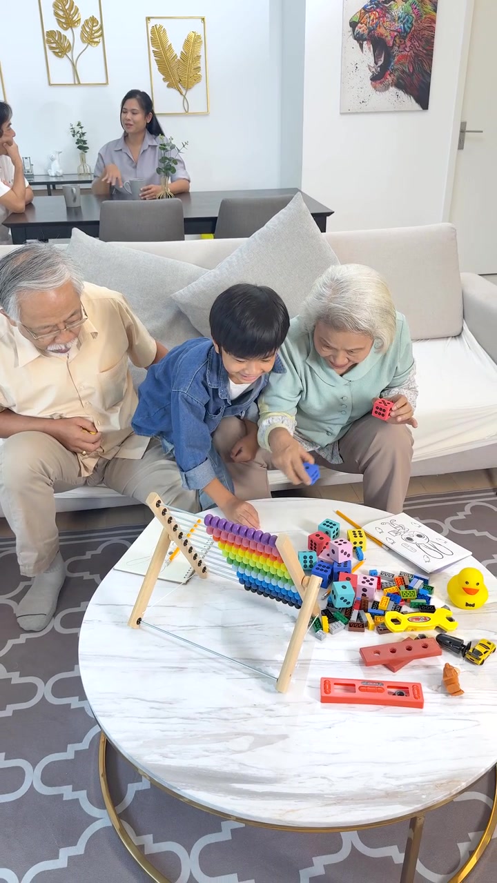 Nonni e bambino si impegnano in un'attività di apprendimento creativo con giocattoli in un luminoso soggiorno