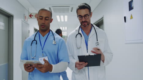 two male doctors talking as they walk in hospital corridor 4k