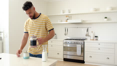 smiling man in kitchen pouring coffee into mug, enjoying morning routine, copy space