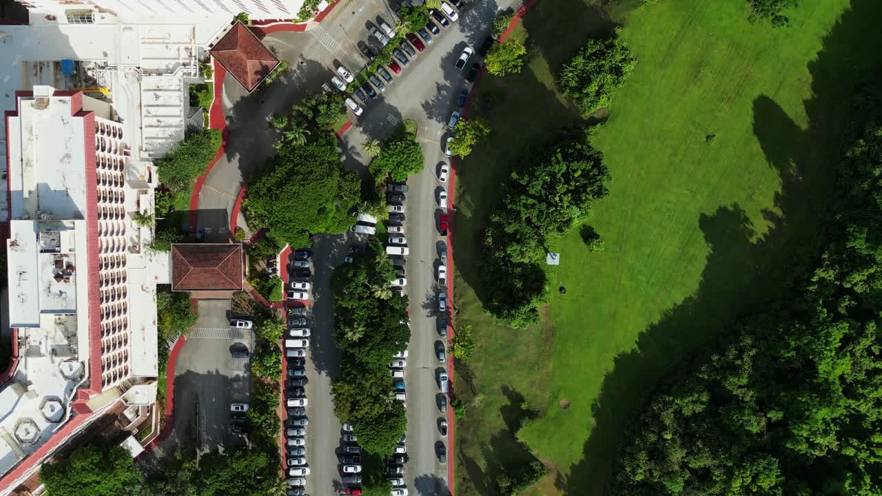 Picturesque bird's eye view of cars and trucks parked along a busy hotel resort parking lot at Tamuning, Guam, USA