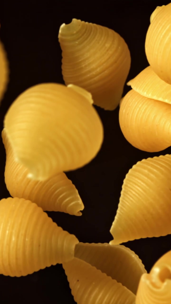 Macro di pasta conchiglie secca su sfondo nero