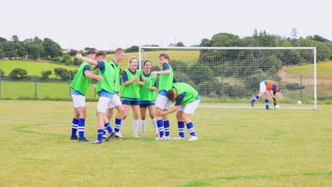 male and female soccer players playing soccer, players embracing and celebrating victory on pitch