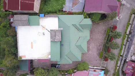 Drone flyover houses with green and red roof in a quiet village in Asia,  Indonesia