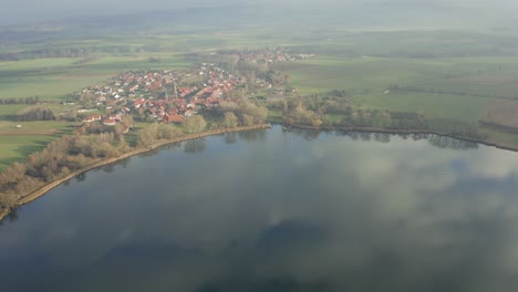 Drone-aerial-of-the-typical-german-village-Seeburg-located-at-the-Seeburger-See-on-a-beautiful-Sunday-morning