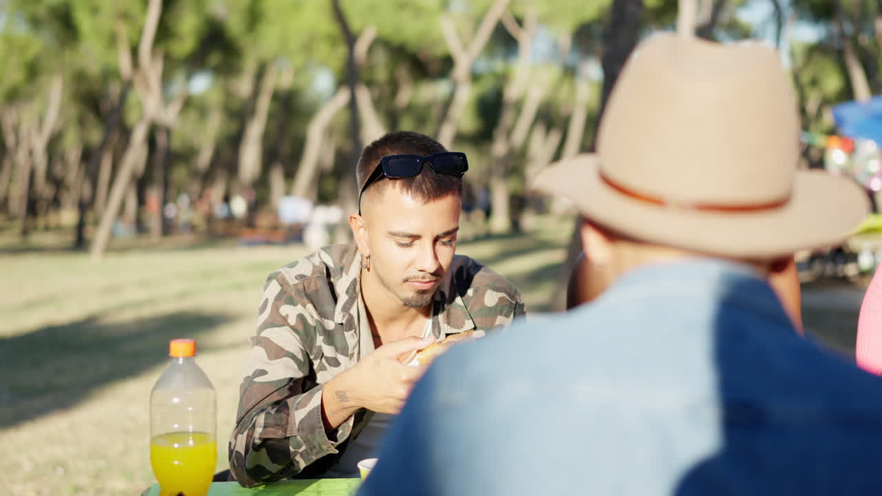 Friends Enjoying a Picnic and Eating Outdoors