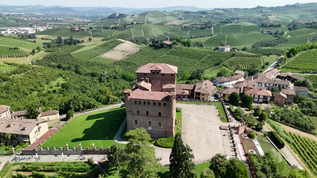 Grinzane Cavour castle, UNESCO site, Cuneo, Piedmont, Italy. 4k aerial view of the castle together with the Vineyard. Langhe-Roero and Monferrato. Tilt up moving forward.