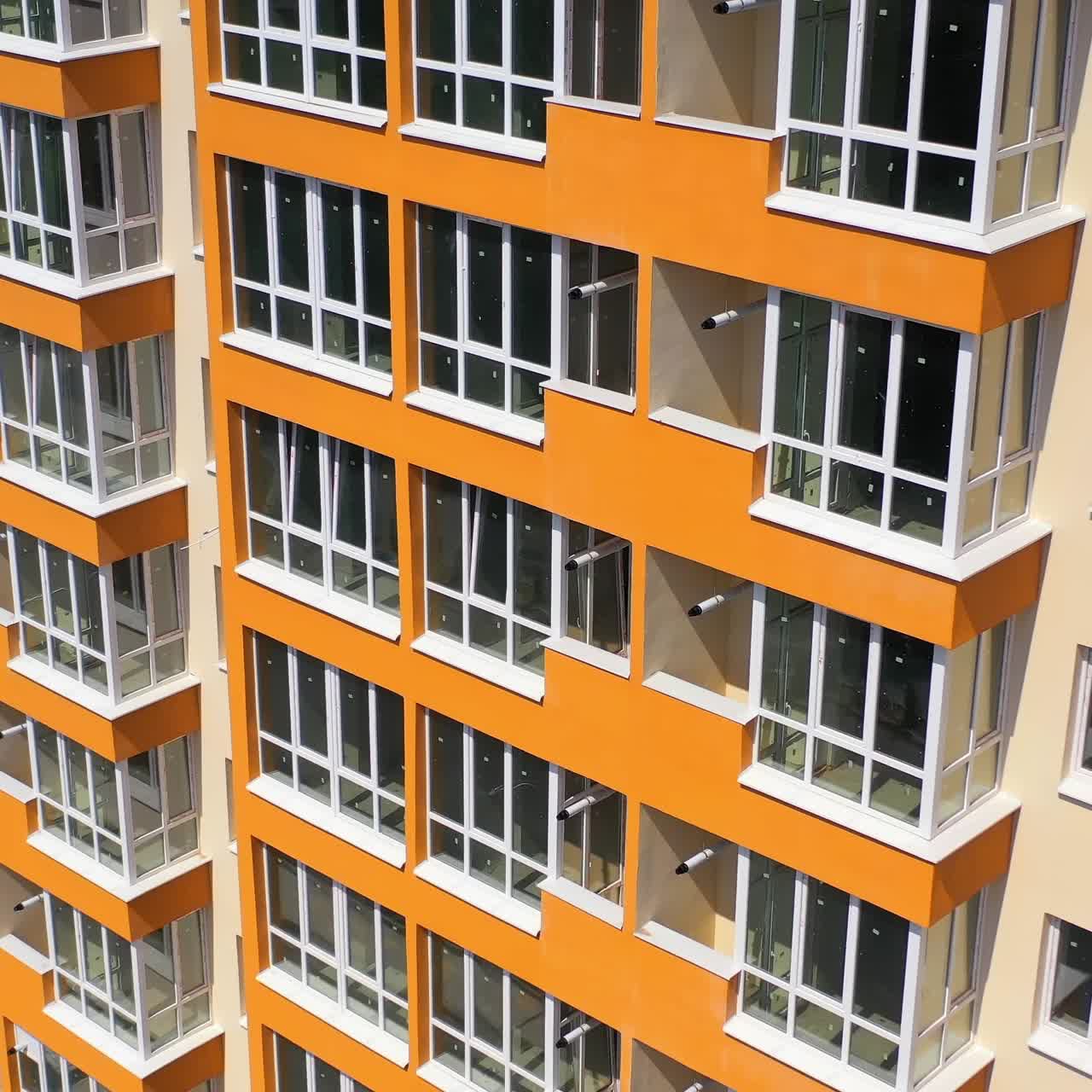 New block of flats with colorful walls. Contemporary high-rise building with large windows. Multi storey house for residents in the city