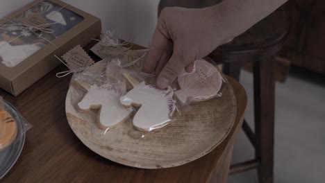 poner galletas de mantequilla con forma de unicornio en un plato de madera en una pastelería artesanal, 4k