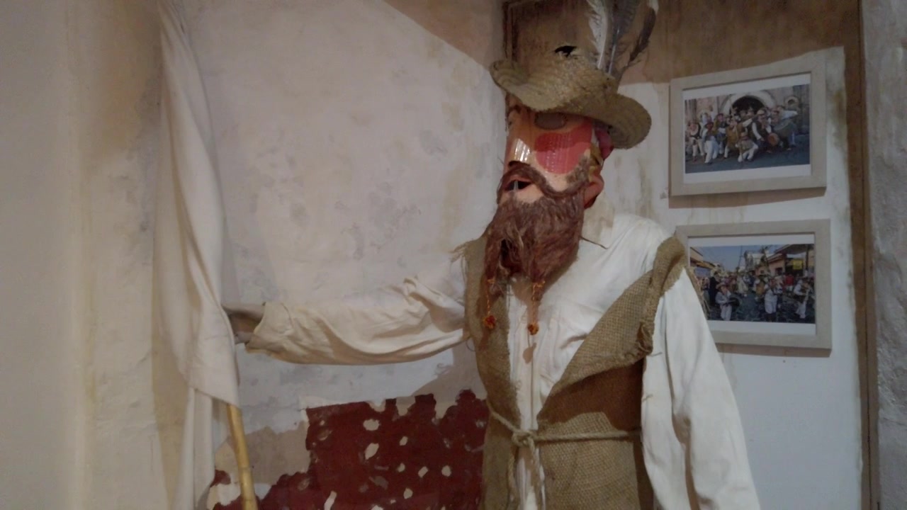 Mostra museale con una figura in costume tradizionale con cappello, maschera e bastone, che espone il patrimonio culturale regionale all'interno di uno spazio espositivo storico in Messico