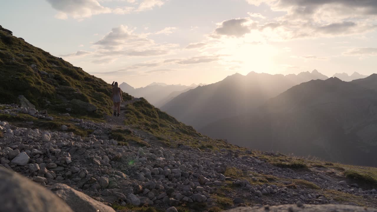 Woman Hiking in the Mountains at Sunset