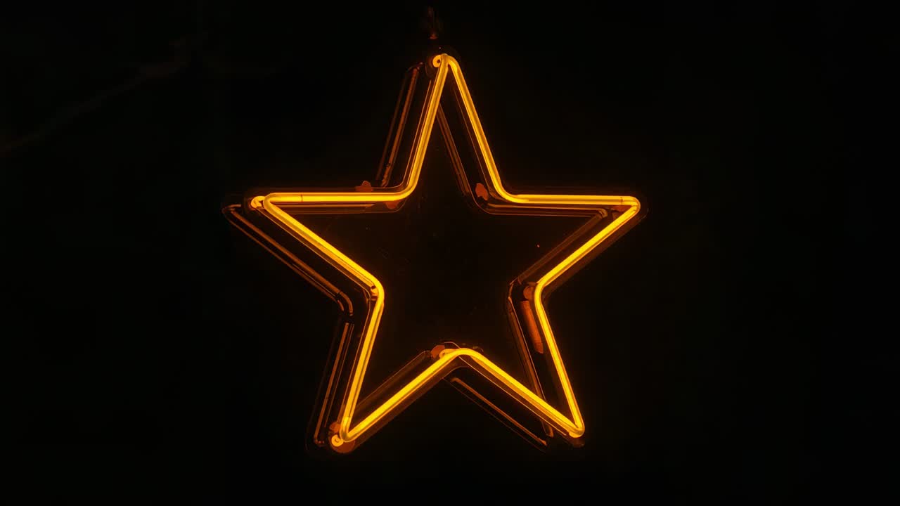 La telecamera si avvicina a una stella al neon a cinque punte illuminata, rivelando catene, clip e tubi in un display fioco