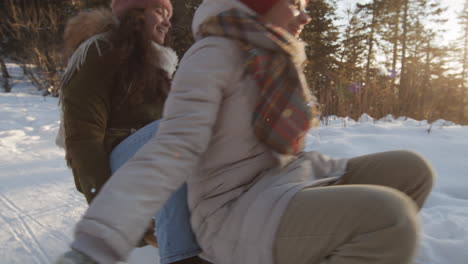 two girls sledding in winter wonderland