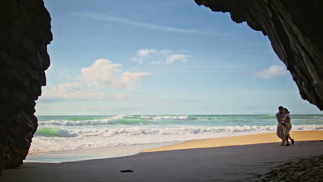 carefree family going beach sand to cliff shadow. expectant parents walking