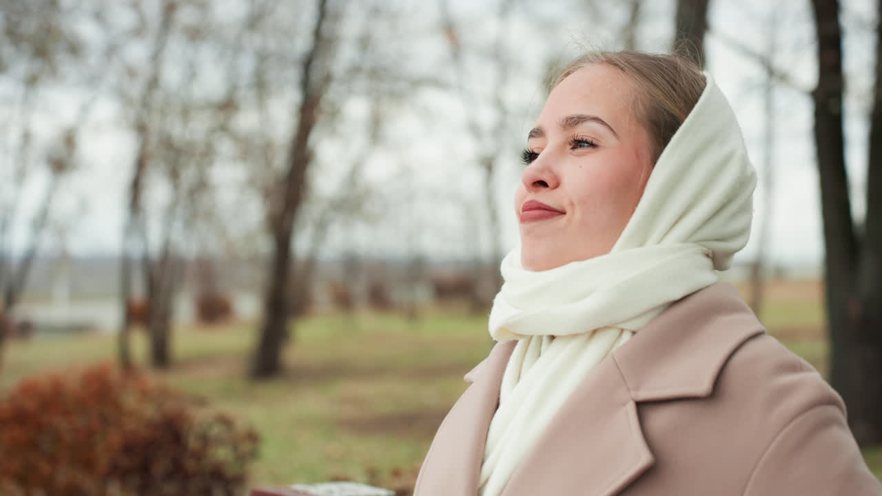 Kadın açık havada dinleniyor. Kadın, doğada huzur içinde dinlenerek sakin bir an yakalar. Parkta yemyeşil ağaç dallarının altında keyifle otururken dingin bir rahatlama yaşıyor.