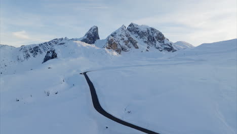 Aerial-View-Of-Empty-Giau-Pass-Surrounded-By-Snow-Covered-Landscape-Near-Mountain-Top