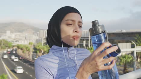 woman wearing hijab drinking outside