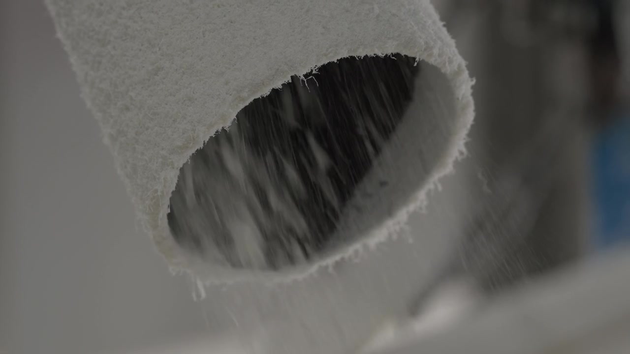 plastic granules and shredded material pour out from industrial plastic grinding machine exhaust pipe