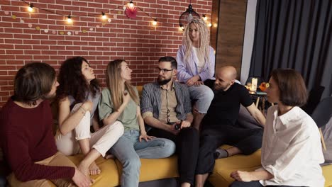 grupo de hombres y mujeres caucásicos felices en conversación en el sofá