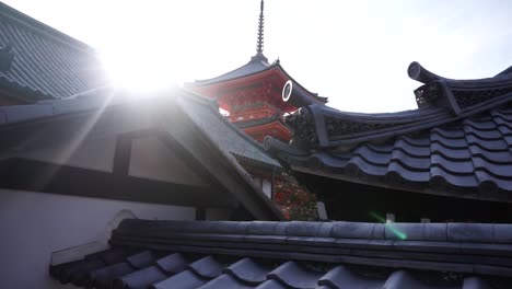 Reveal-upwards-of-a-traditional-Japanese-pagoda-at-one-of-the-landmarks-and-most-popular-destinations-in-Kyoto,-Japan-with-a-bright-sun