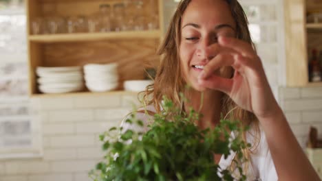 Mujer-Caucásica-Sonriente-Tocando-La-Planta-En-La-Cocina-De-La-Cabaña