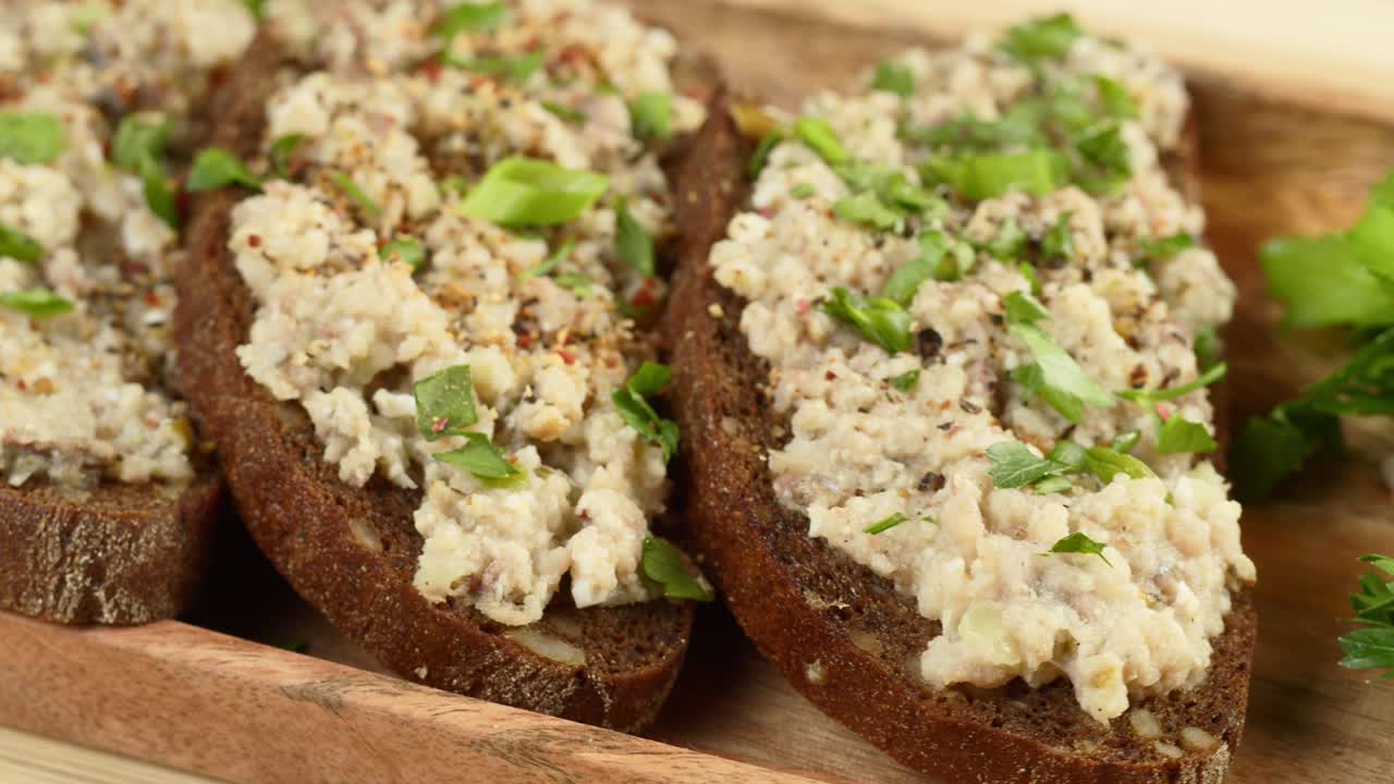 cocina israelí. forshmak con perejil y especias en pan de centeno negro de primer plano. plato nacional de arenque judío, cultura de oriente medio. bocadillo tradicional vorschmack hecho de filete de pescado giratorio