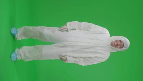 full body of asian male wearing personal protective equipment uniform ppe and smiling to camera in green screen studio