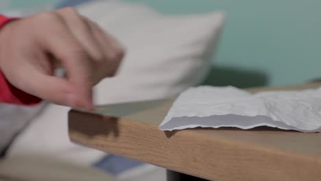 pan right to left shot of a man taking rinkled page from a table