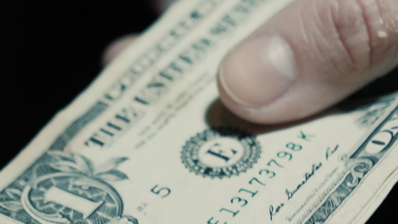 Nærbillede af en hånd, der tæller amerikanske dollarsedler
