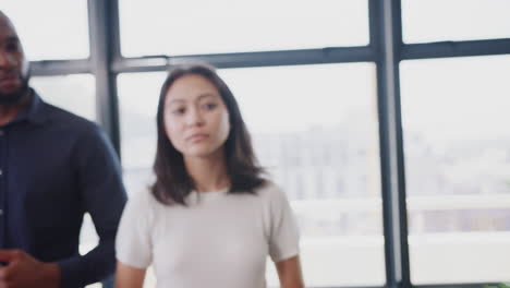 Close-up-of-creative-colleagues-listening-to-manager-at-an-informal-office-meeting,-arc-shot