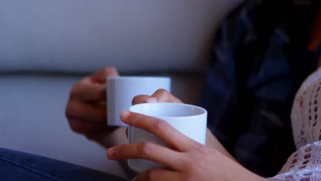 couple having coffee on sofa at home 4k