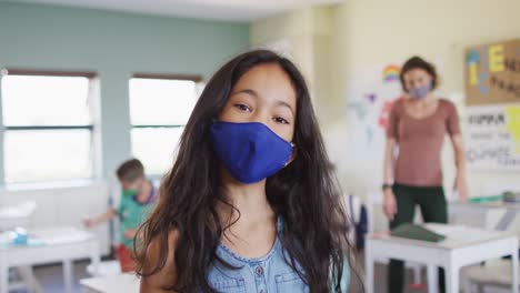 retrato de una niña con una máscara facial en clase en la escuela