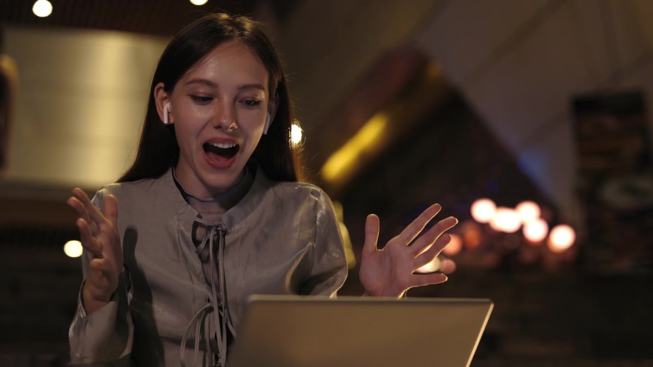 Giovane donna impegnata in una videochiamata sul laptop con auricolari wireless