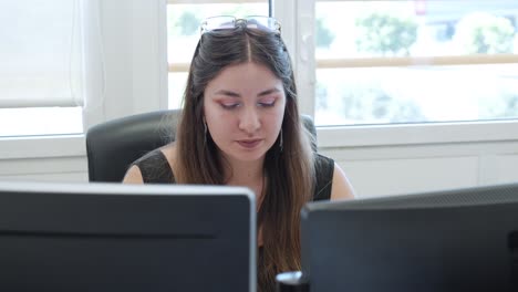Young Woman Working on Computers in an Office