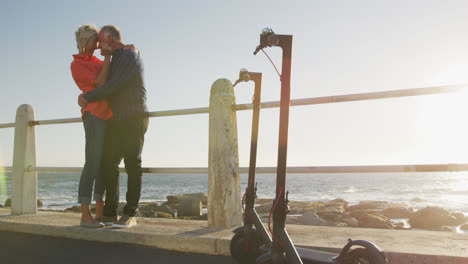 senior couple embracing each other alongside beach