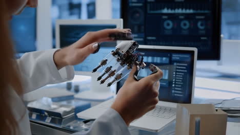 scientist working on a robotic hand prosthesis in a lab
