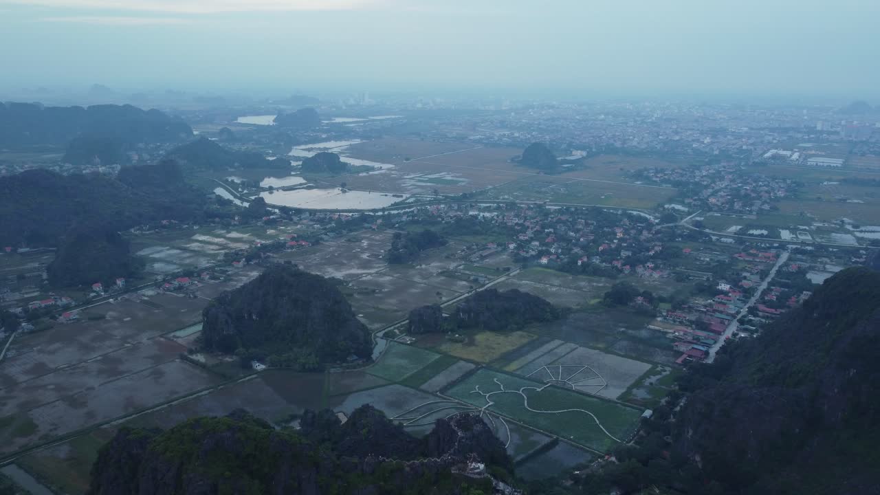 Tam Cốc, Việt Nam, với những cánh đồng lúa thanh bình, núi đá vôi và không khí yên tĩnh, nhìn từ trên không.