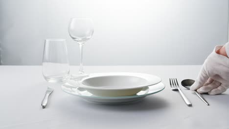 elegant table setting with white tableware plates, cutlery, and glassware for a classy dining, fancy expensive restaurant dinner