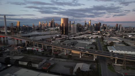 Cars-driving-up-on-ramp-Bolte-bridge-aerial,-Melbourne-skyline