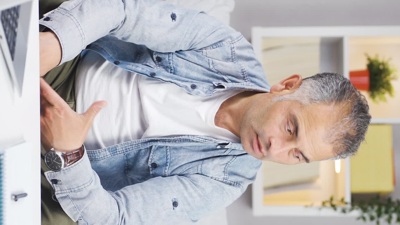 el video vertical del hombre mirando la computadora portátil es desmotivado y aburrido.