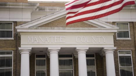 el secretario del condado de manatee de la corte de circuito con la bandera de los estados unidos ondeando en cámara lenta