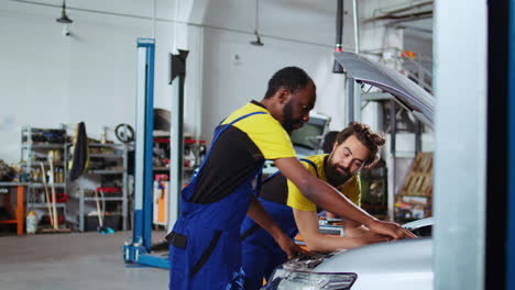 servicemen working together to fix car