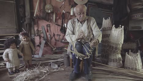 basket weaving master shapes wooden sticks. 4k footage. craft concept.