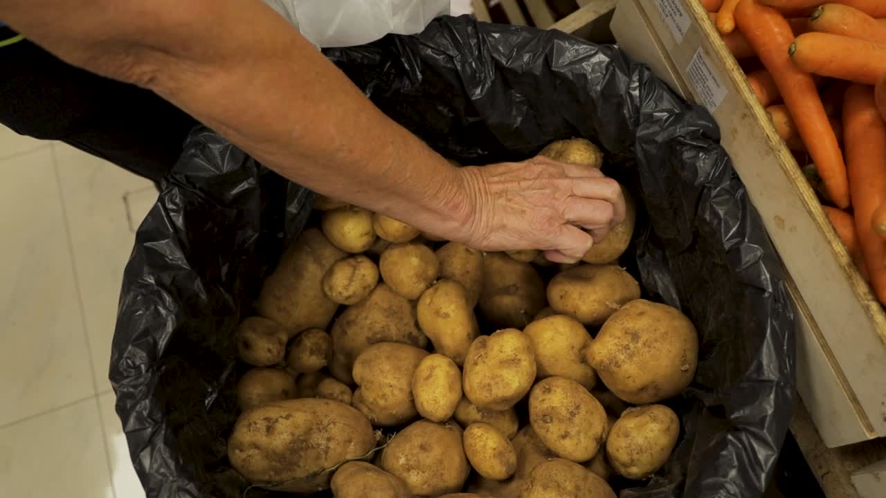Prendere una patata da un sacchetto al mercato.
