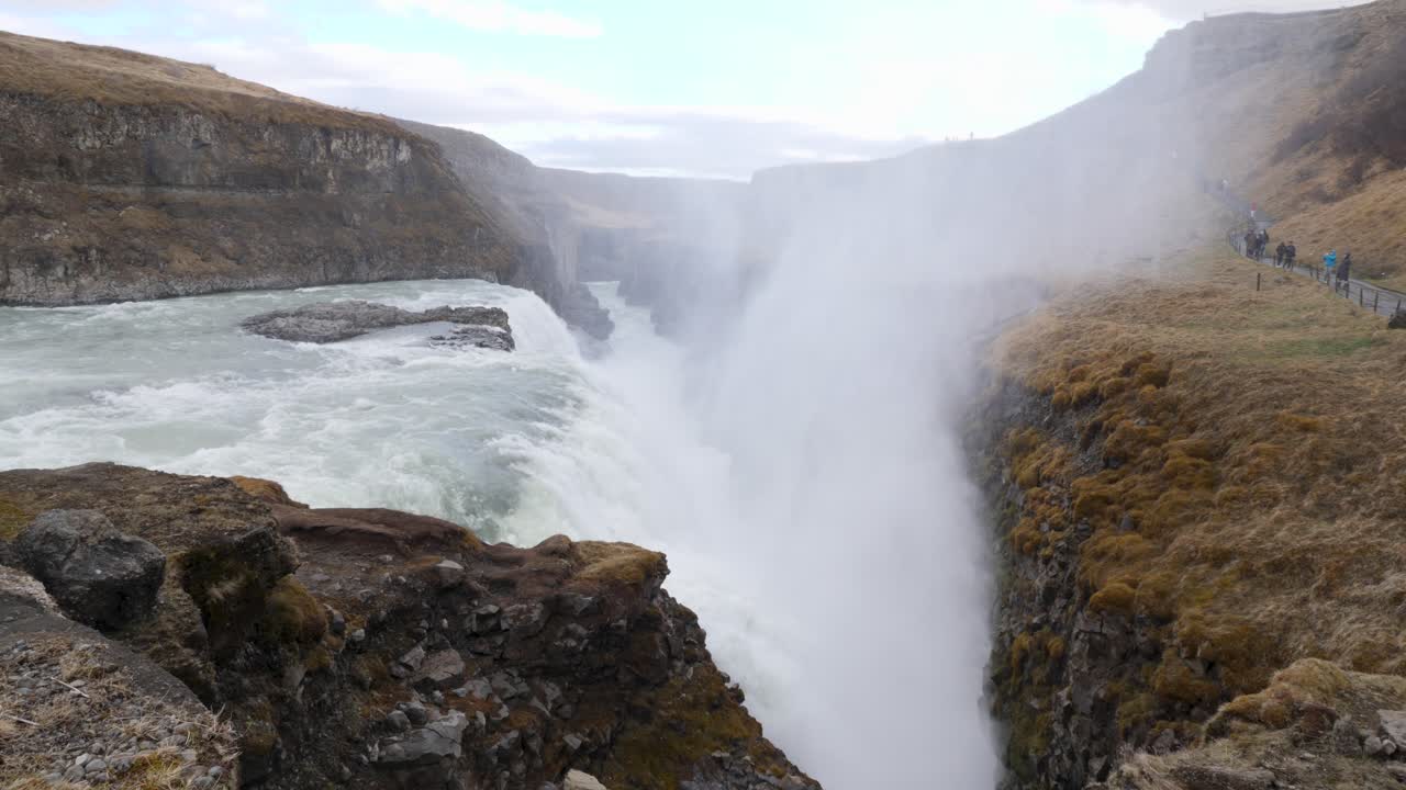 vapor moviéndose hacia arriba mientras el agua fluye hacia abajo sobre la cascada del golfo en islandia