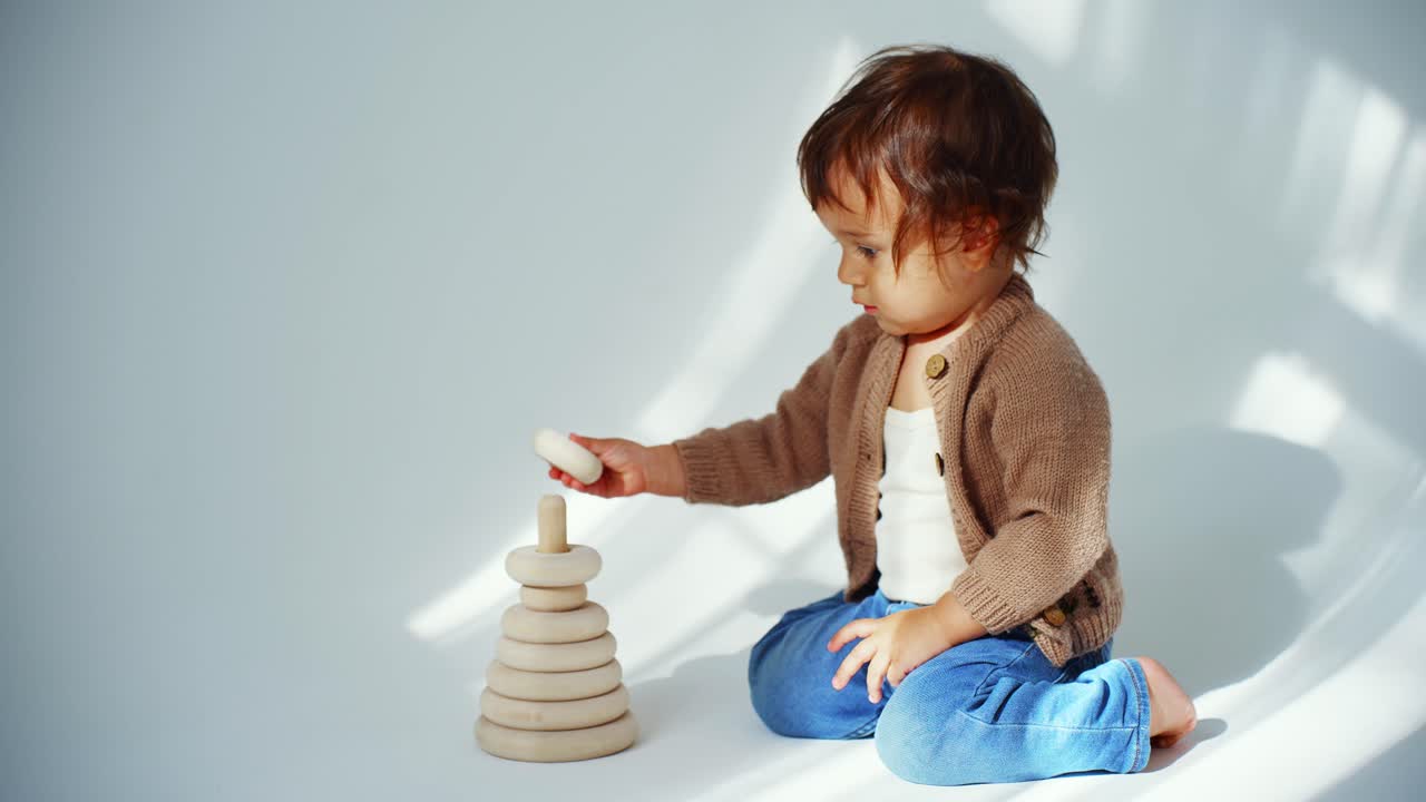 Cute Toddler Playing with Wooden Stacking Toy on White Background
