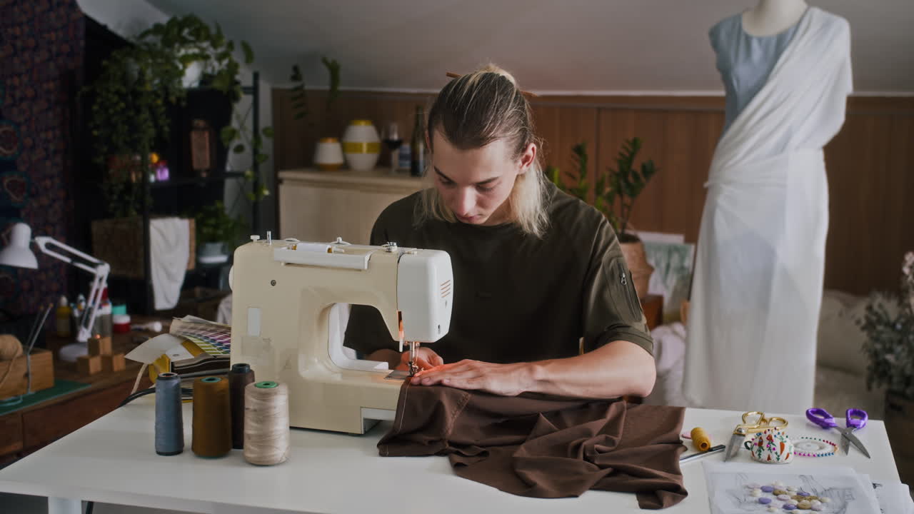 Stilista di moda della Gen Z che lavora alla macchina da cucire in studio