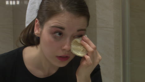 woman removing makeup in bathroom