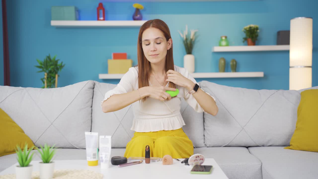 머리카락을  ⁇ 는 젊은 여성. 머리카락 관리.